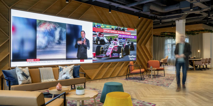 A conference room with a long table and chairs and a projector screen.