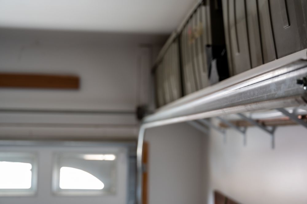Garage ceiling with metal storage shelves and stacked bins above a door