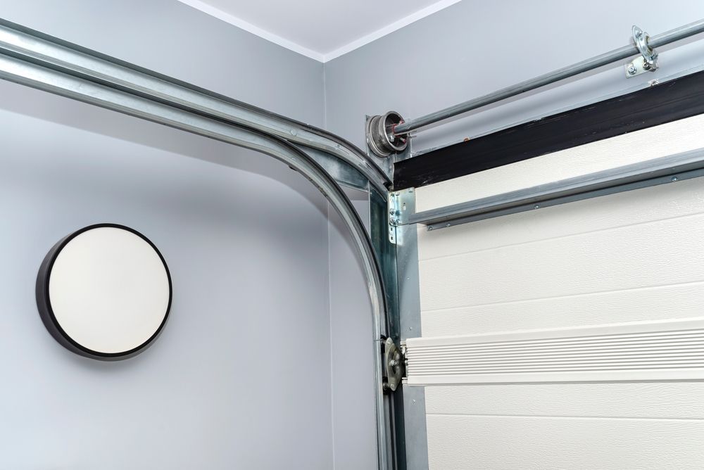 Garage interior with a closed white sectional door and metal track hardware on the ceiling