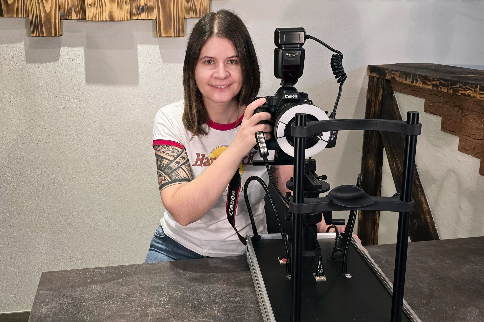 Frau neben einer Kamera auf einem Stabilisierungsgestell, lächelnd in einer Studioumgebung bei Iris-Fotografie.