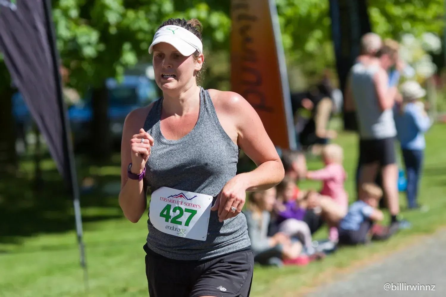 A woman is running a marathon in a park.