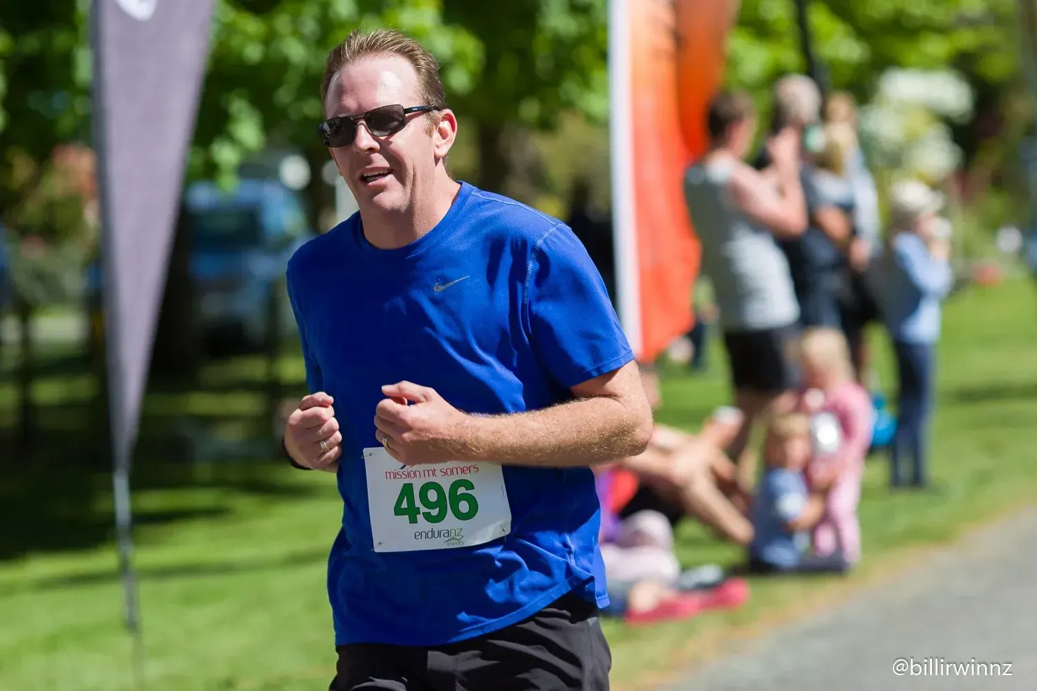 A man in a blue shirt is running in a race.