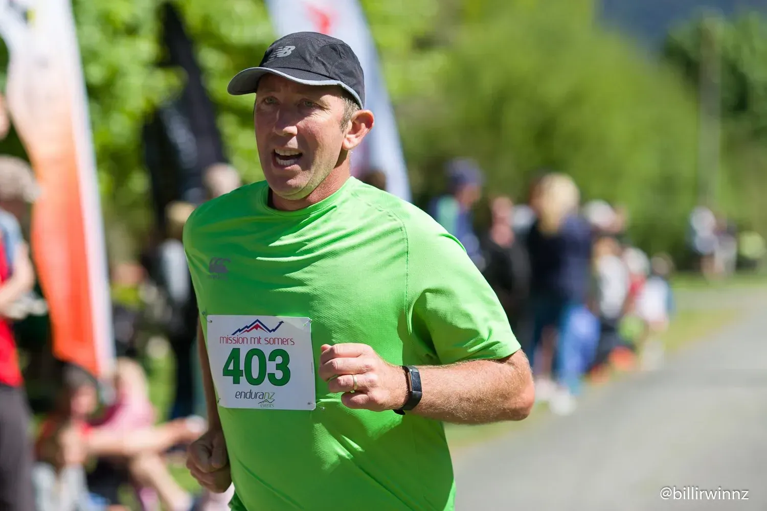 A man in a green shirt is running in a race.