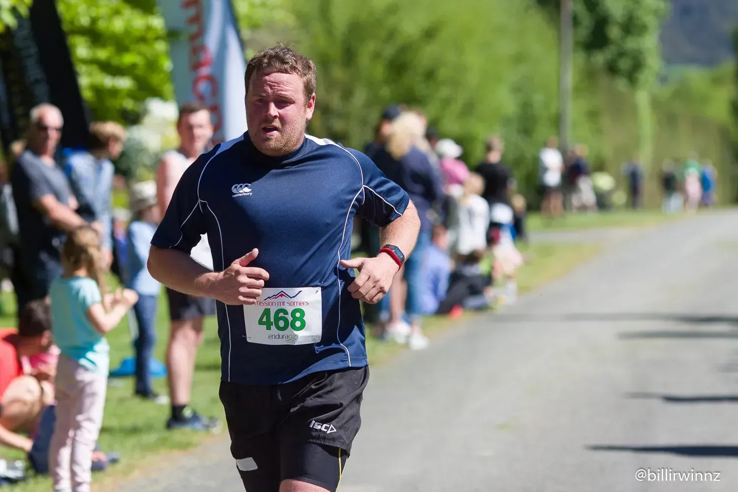 A man is running in a race with a number on his shirt.