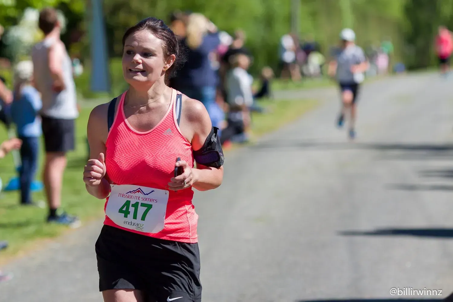 A woman is running in a race with a number on her shirt.