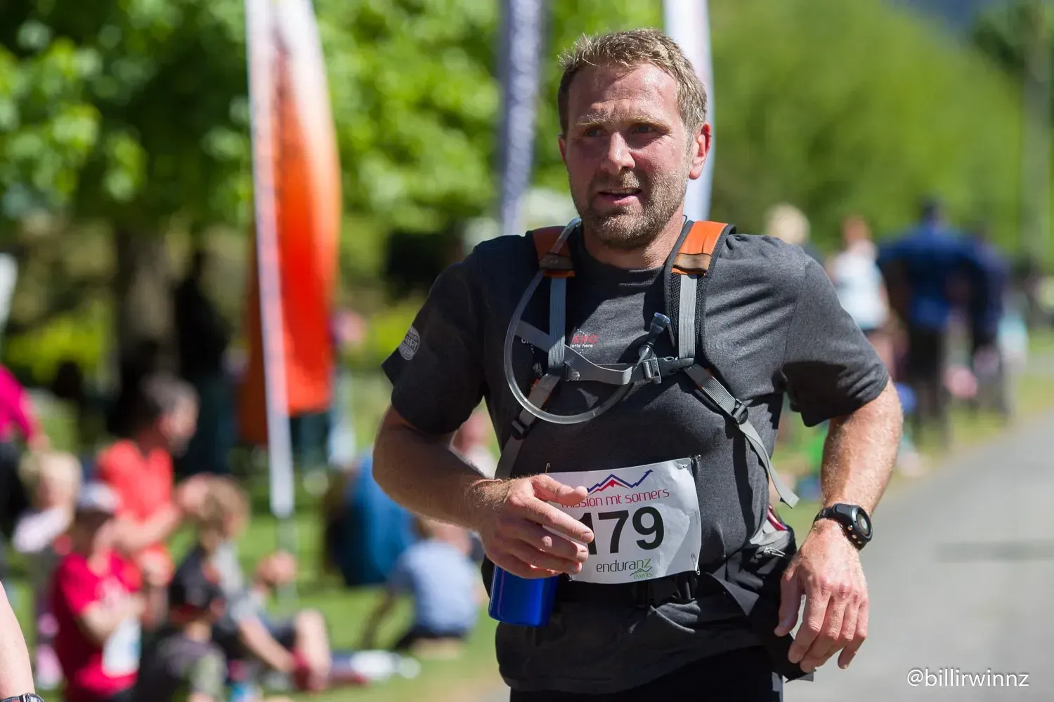 A man is running in a race with a number 79 on his shirt.