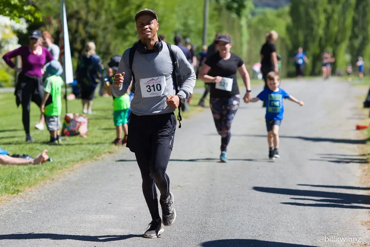 A group of people are running down a road.