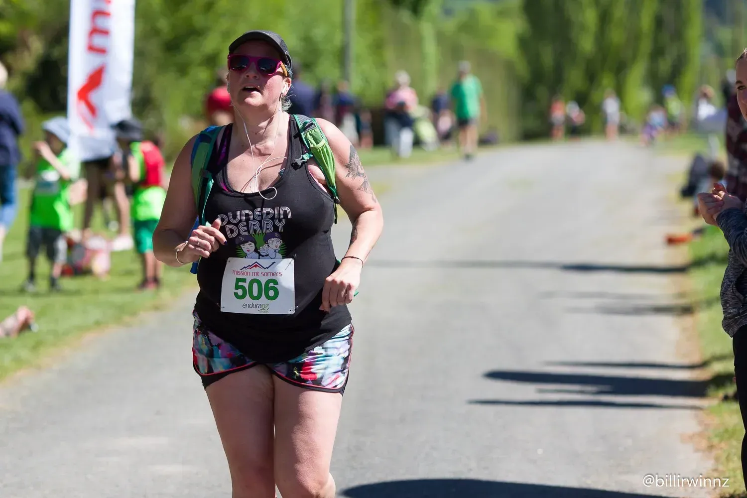 A woman is running a race on a road.