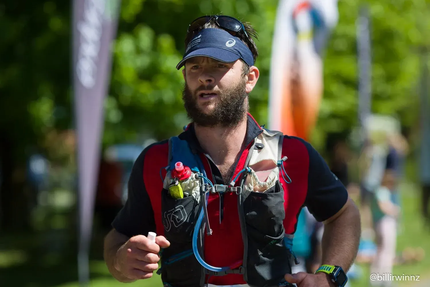 A man with a beard is running in a park.