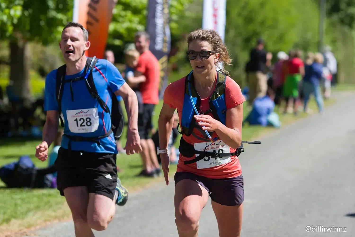A man and a woman are running a race on a road.