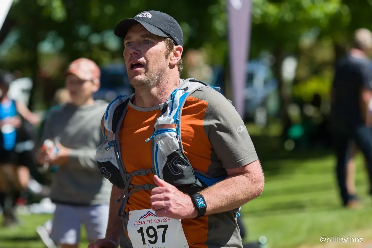 A man is running in a race with a number 197 on his shirt.