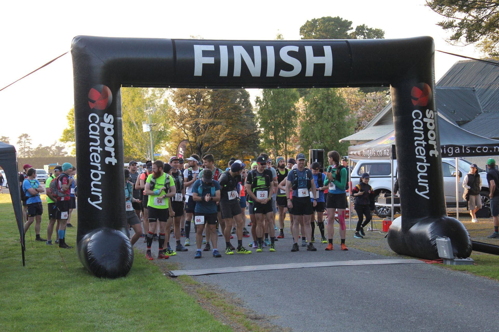A group of people are running under an inflatable arch that says finish