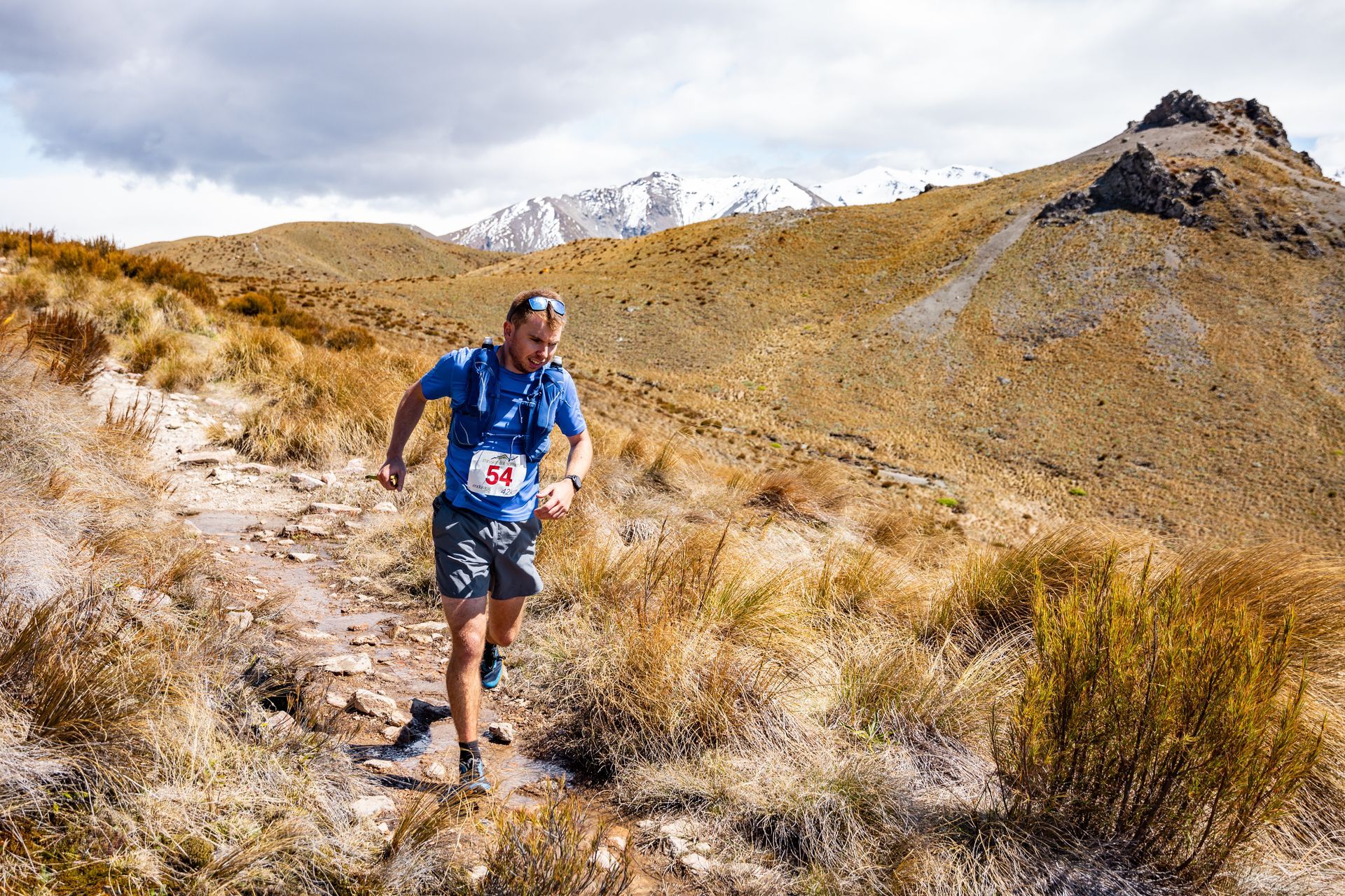 A man is running on a trail in the desert.