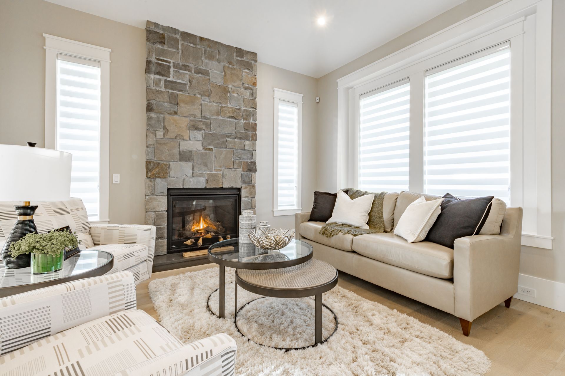 A living room with a couch , chair , coffee table and fireplace.