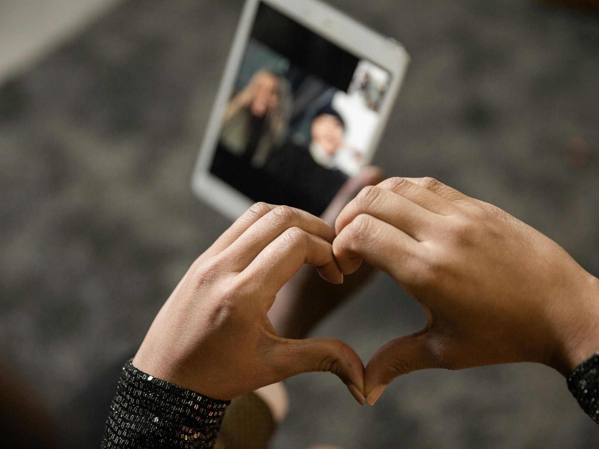 Hands typing on a smartphone beside a cup of coffee on a white table