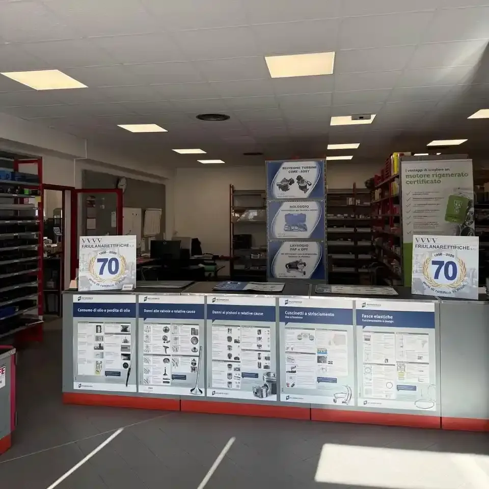All'interno di un negozio ben illuminato, file di scaffalature metalliche erano piene di ricambi auto e batterie per automobili.