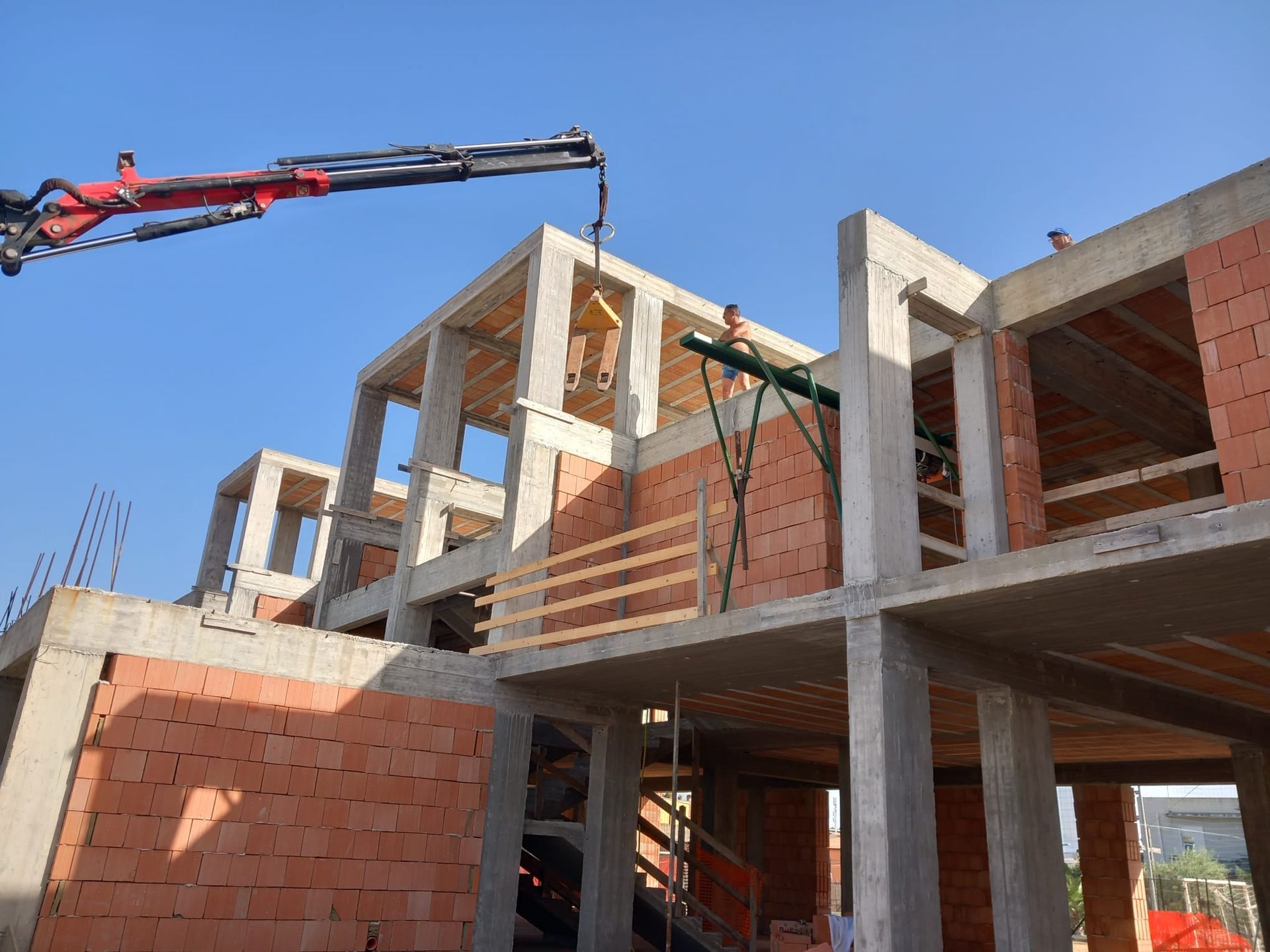 Edificio in costruzione con impalcature contro un cielo nuvoloso.