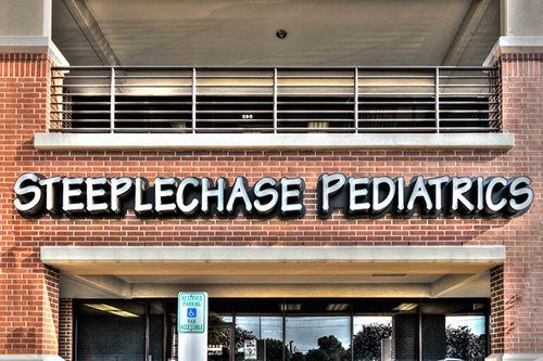 Steeplechase Pediatrics sign on a brick clinic building entrance