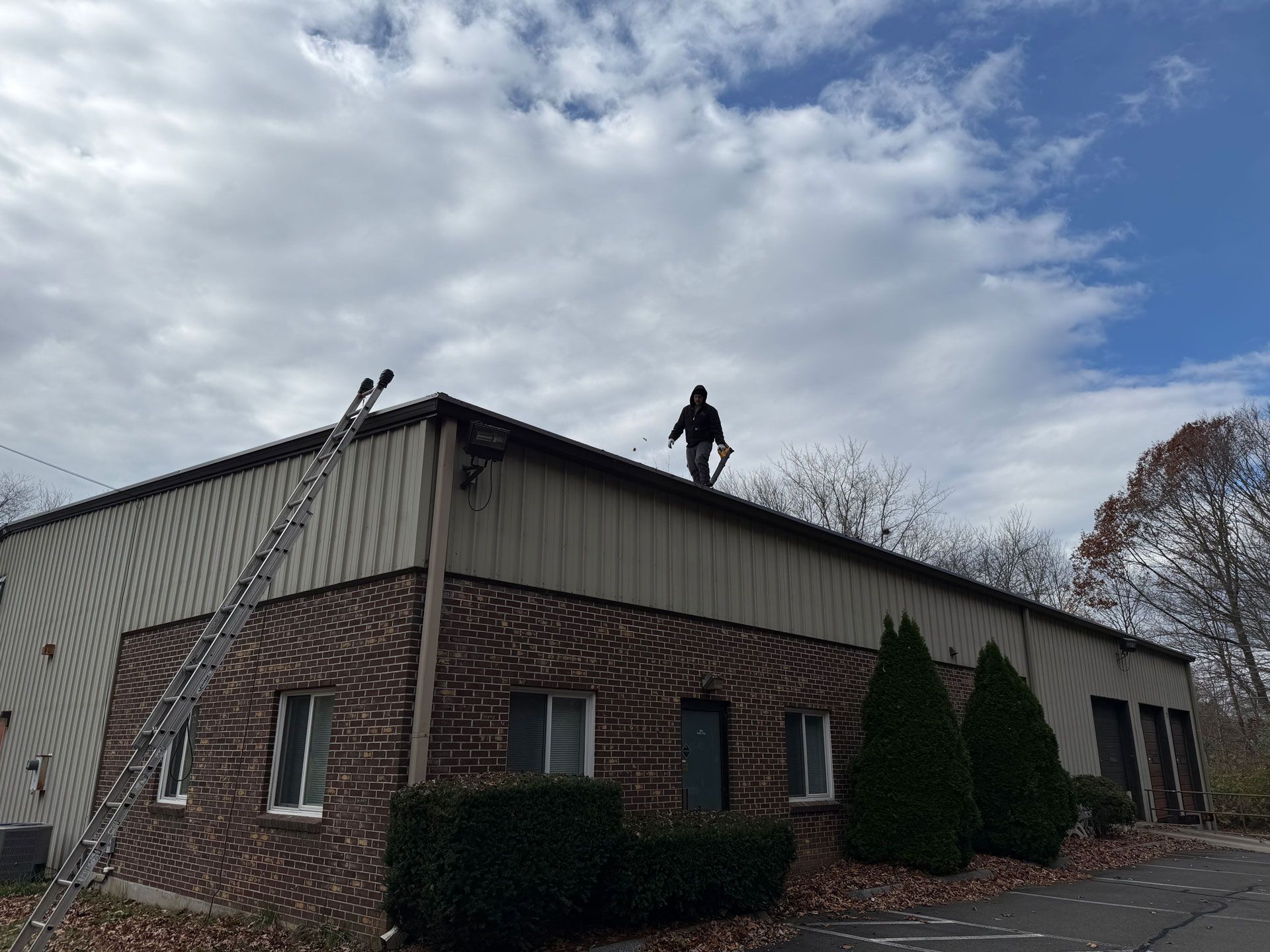 Two people on a rooftop of a brick building under a cloudy sky