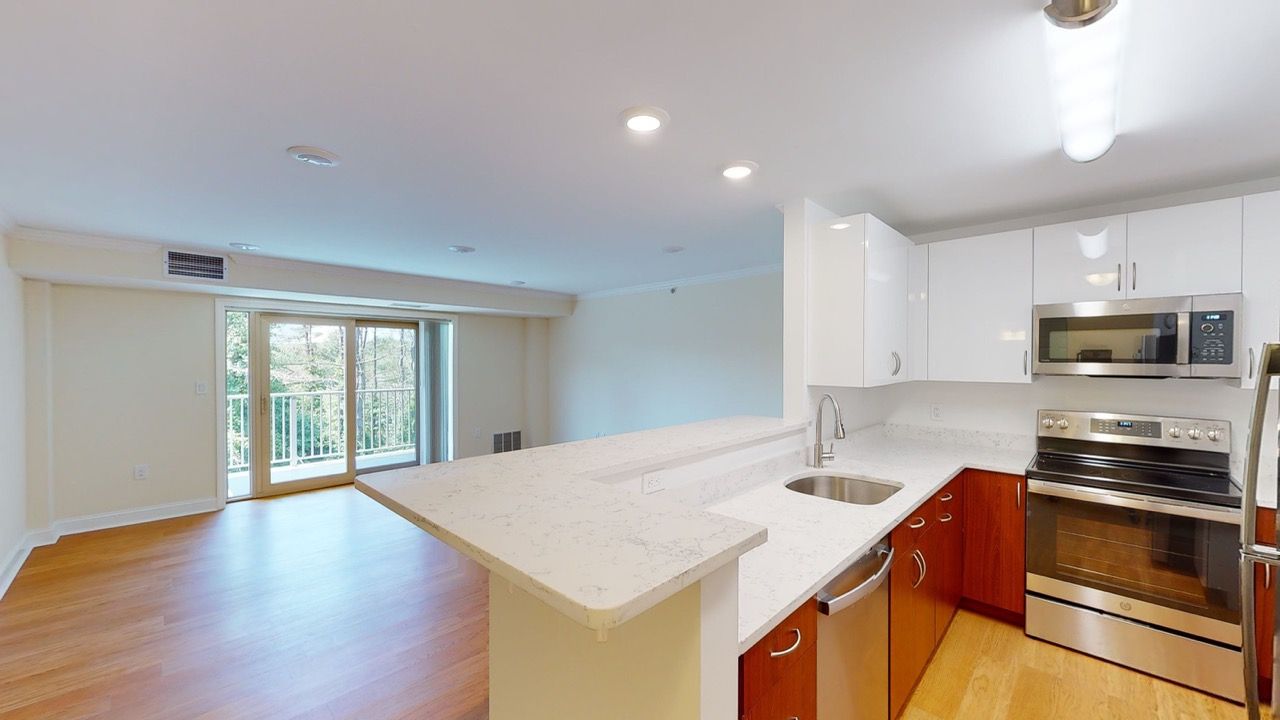 Open-concept kitchen with an island, white countertops, and stainless-steel appliances.