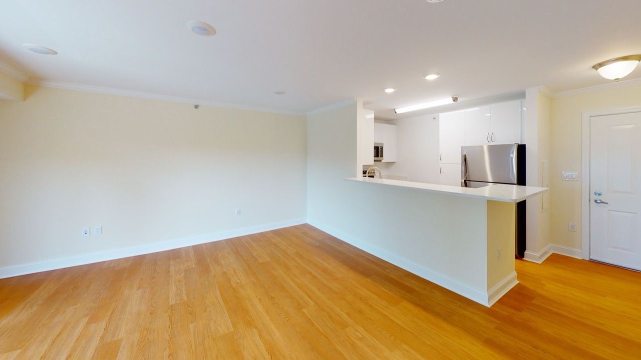 Open-concept living area with hardwood floors and a white kitchen island.