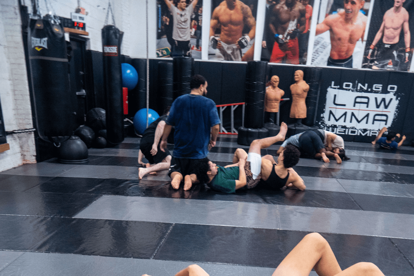 Adults training pads and grappling basics at Ray Longo's Mixed Martial Arts, building fitness and confidence