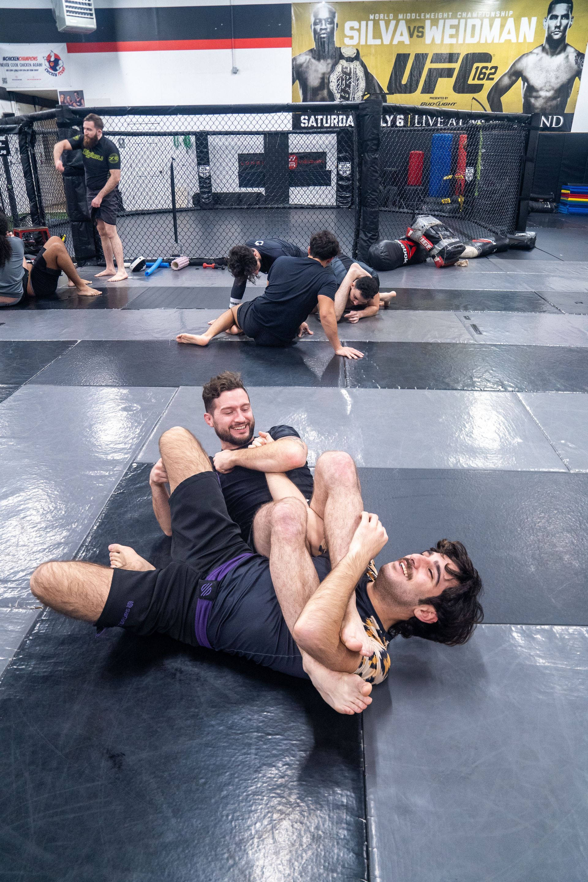 Adults practicing pad work at Ray Longo's Mixed Martial Arts in Garden City, NY for stress relief.