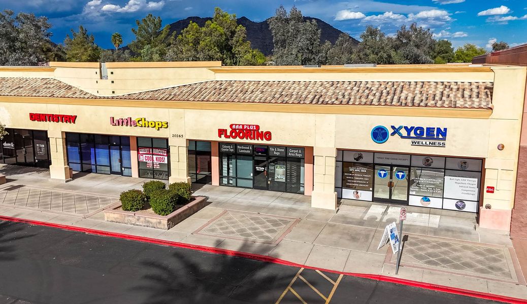 An aerial view of a shopping center with mountains in the background.