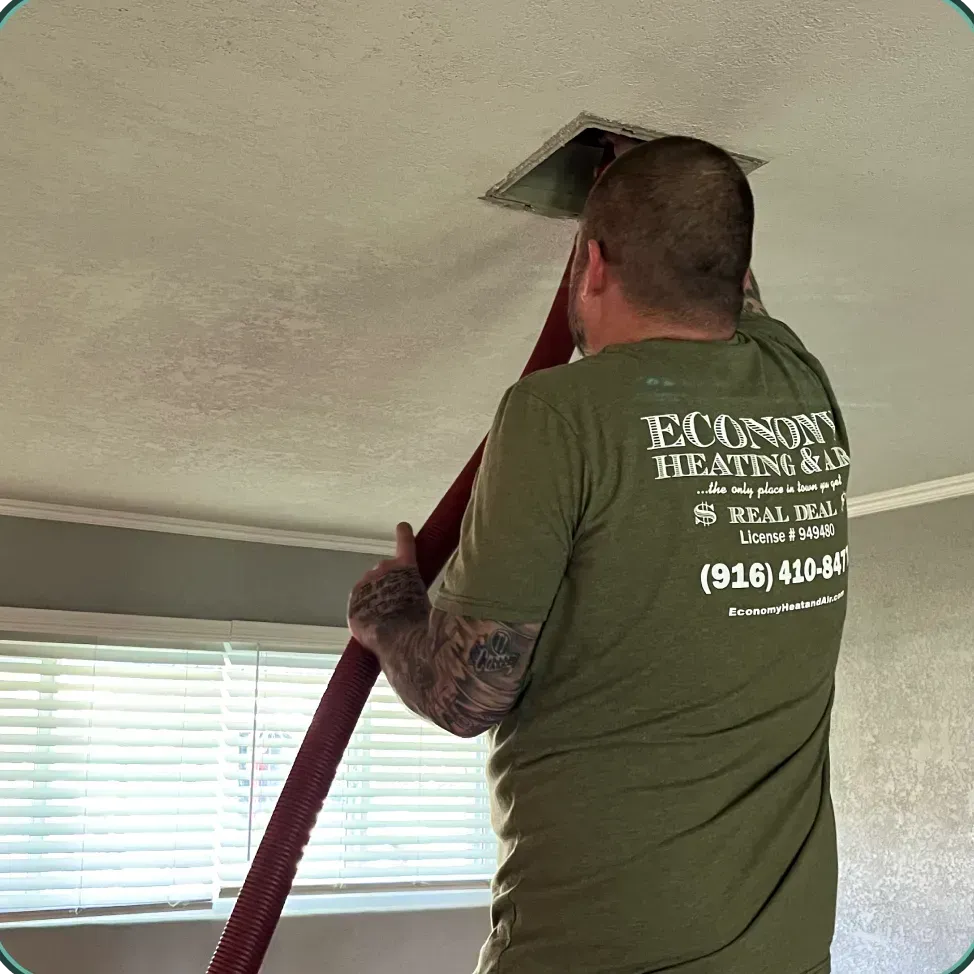 A man wearing a green shirt that says econon heating & cooling