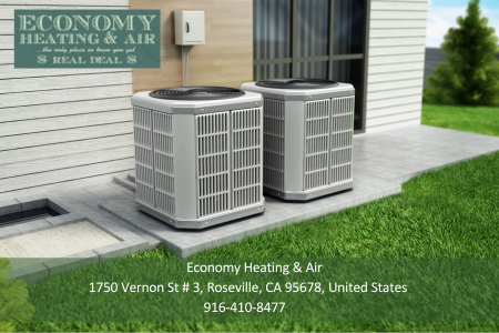 Two air conditioners are sitting outside of a house.