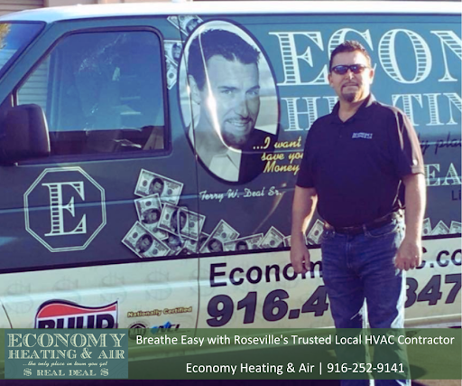 A man standing in front of an economy heating and air van