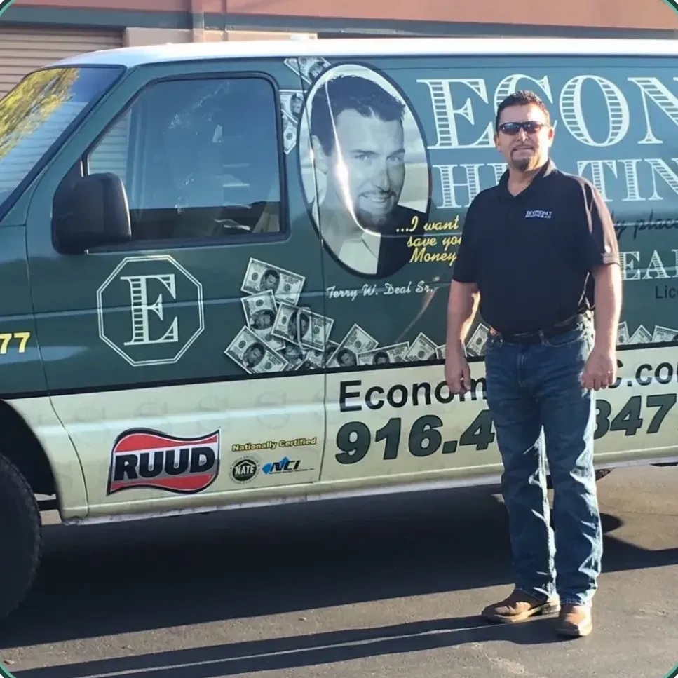 A man stands in front of a green van that says econo health