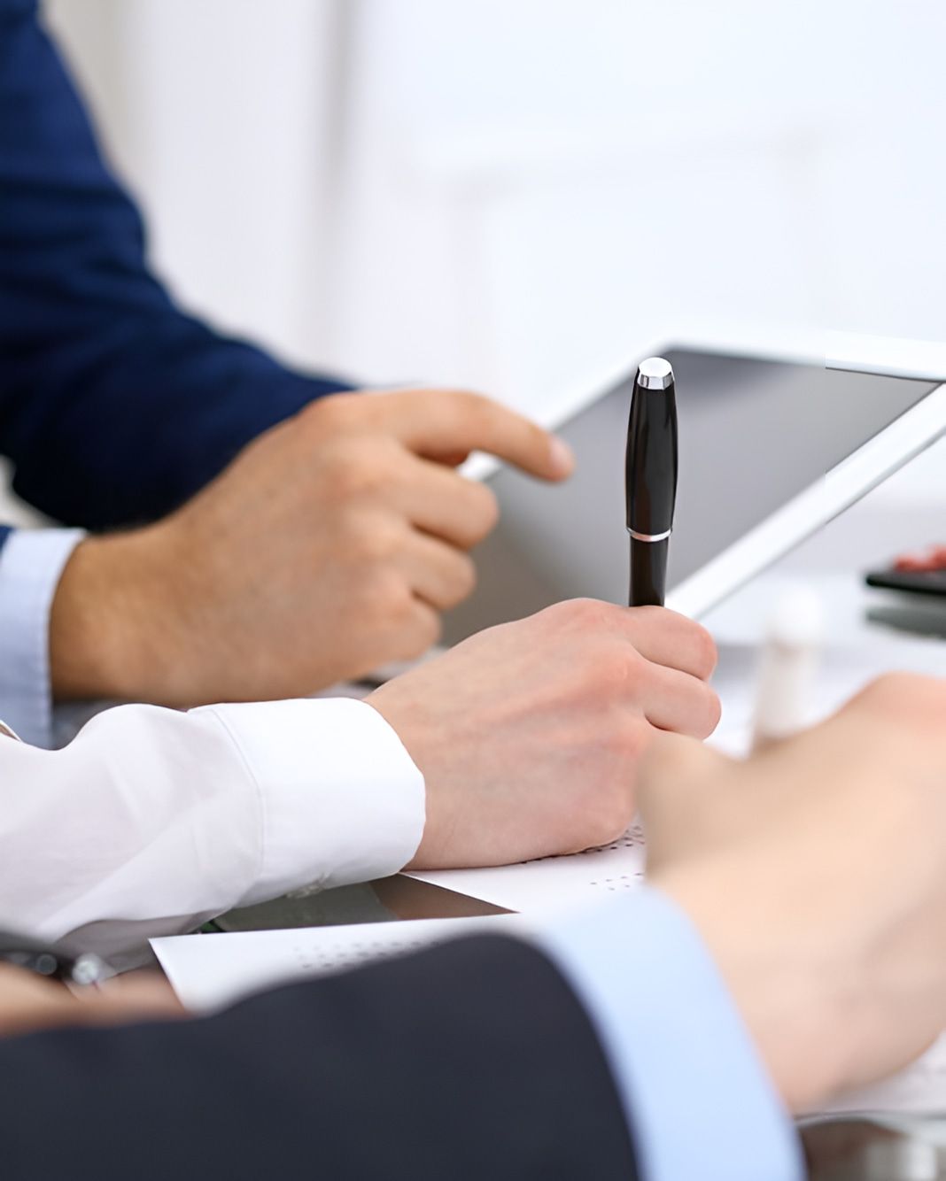 Two People Are Sitting at a Table Using a Tablet and a Pen — AJA Bookkeeping Services In Cairns, QLD