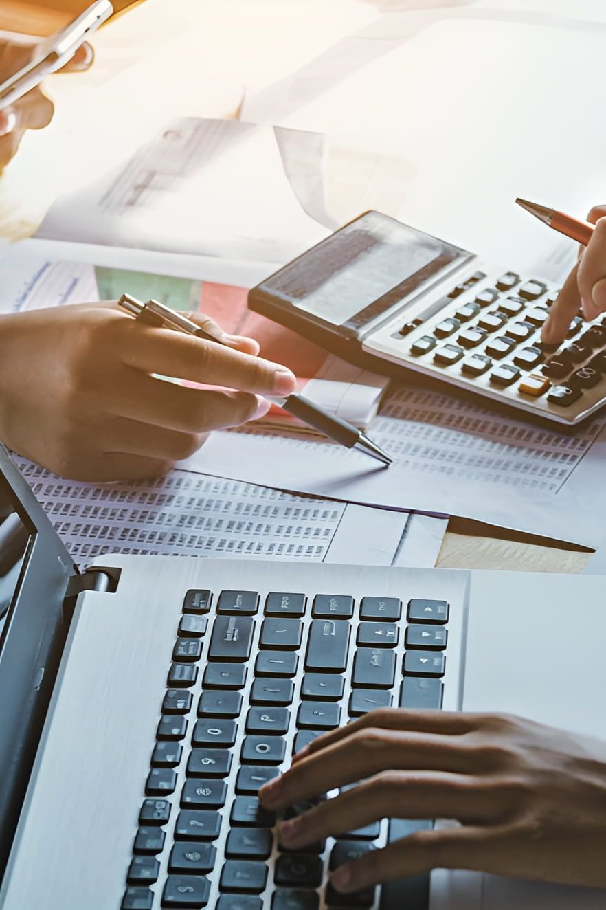 Hands Using Laptop, Calculator, and Papers for Accounting — AJA Bookkeeping Services In Weipa, QLD