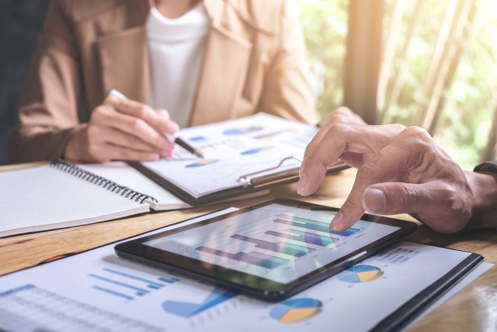 Two People Reviewing Charts and Graphs on a Tablet — AJA Bookkeeping Services In Weipa, QLD