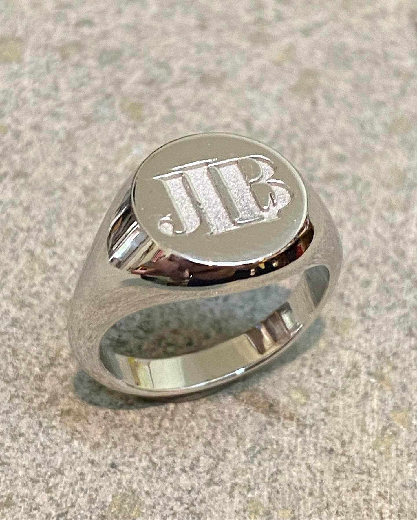 A silver signet ring with the engraved initials