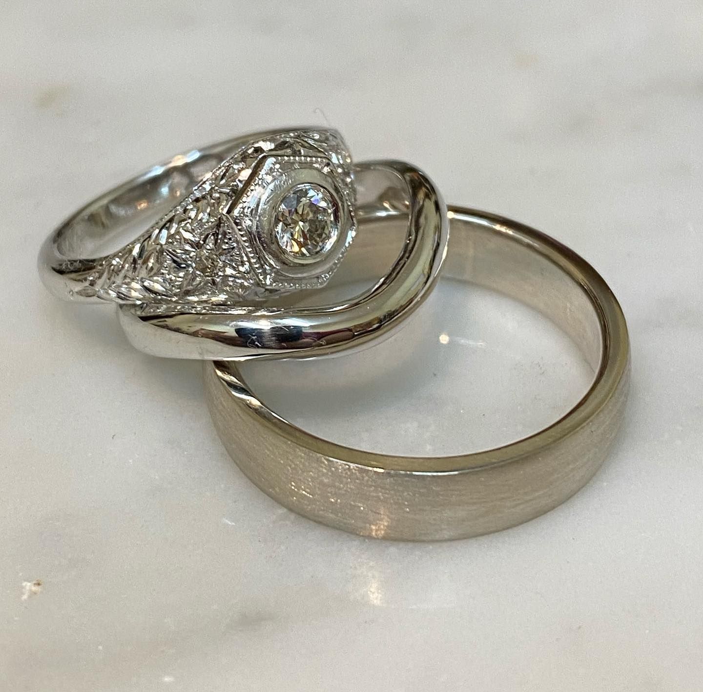 Two Wedding Rings Stacked on a White Marble Surface — Burchell's Jewellers In Sydney, NSW