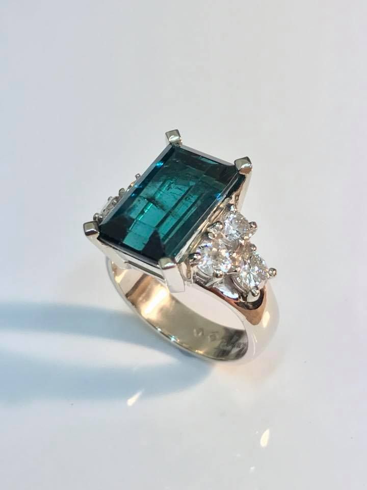Emerald-cut teal gemstone ring, set in white gold, with side cluster diamonds. — Burchell's Jewellers In Canberra, NSW