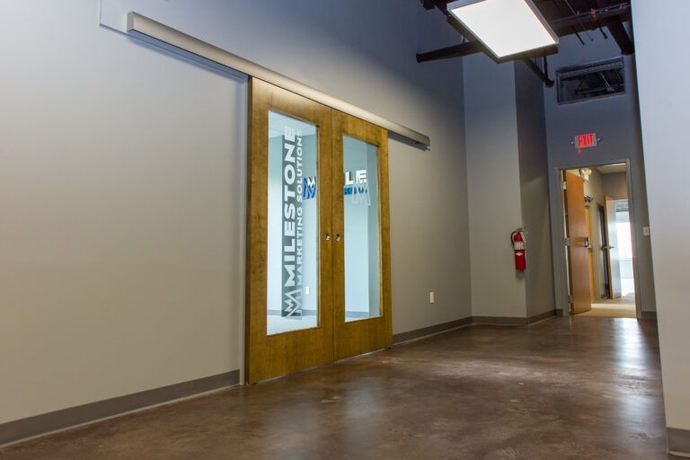 A sliding wooden door with glass panels labeled