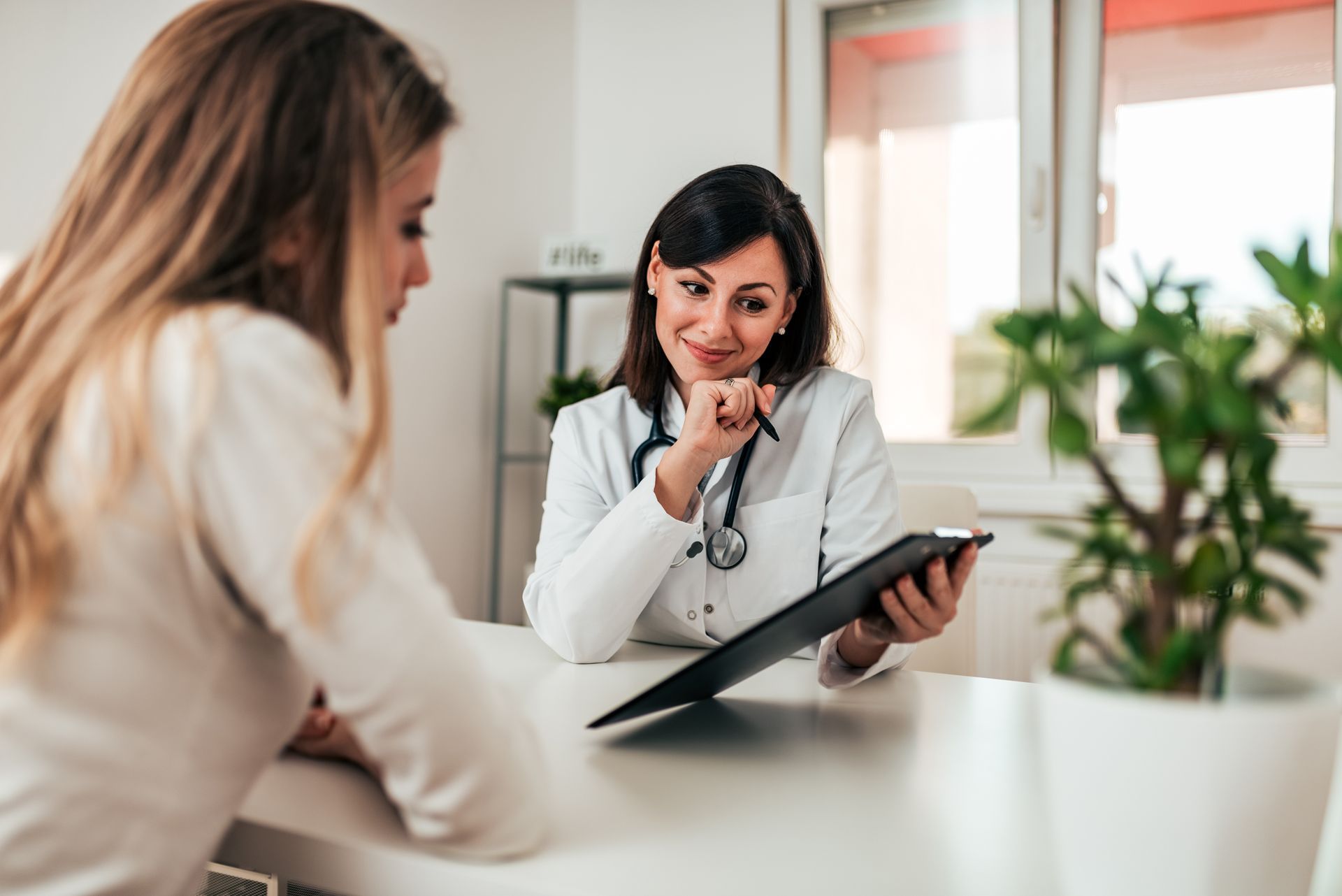 female doctor consulting with female patient in office