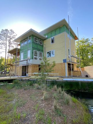 A large house is being built next to a body of water.