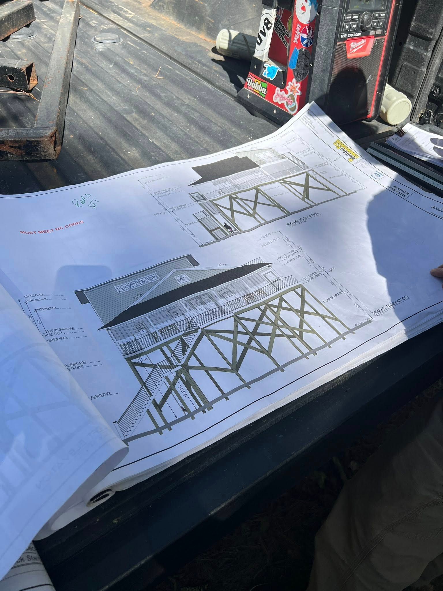 Architectural blueprints of two water towers on a truck bed.