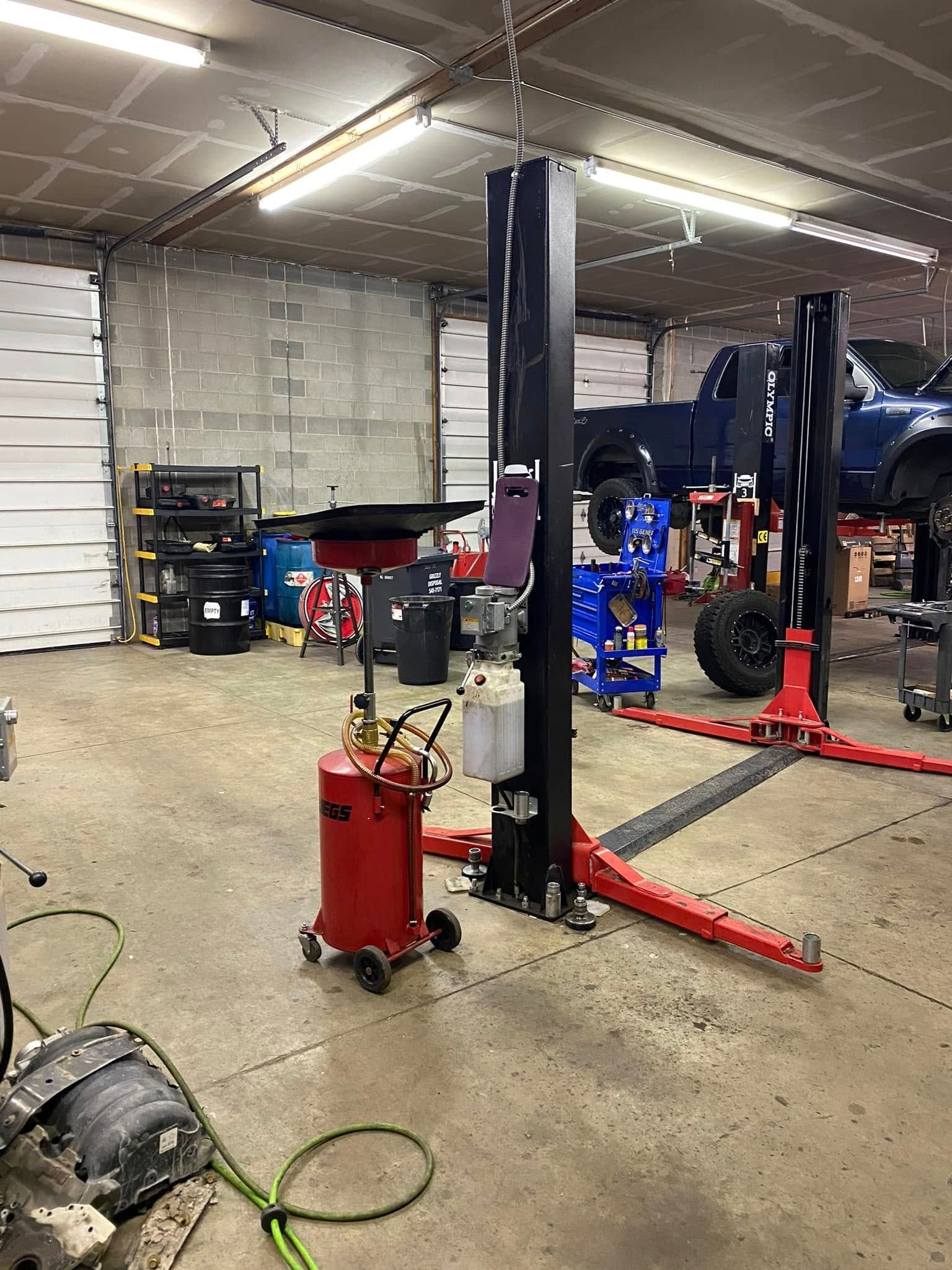Auto repair shop with a red car lift, tools, and equipment in a garage workspace