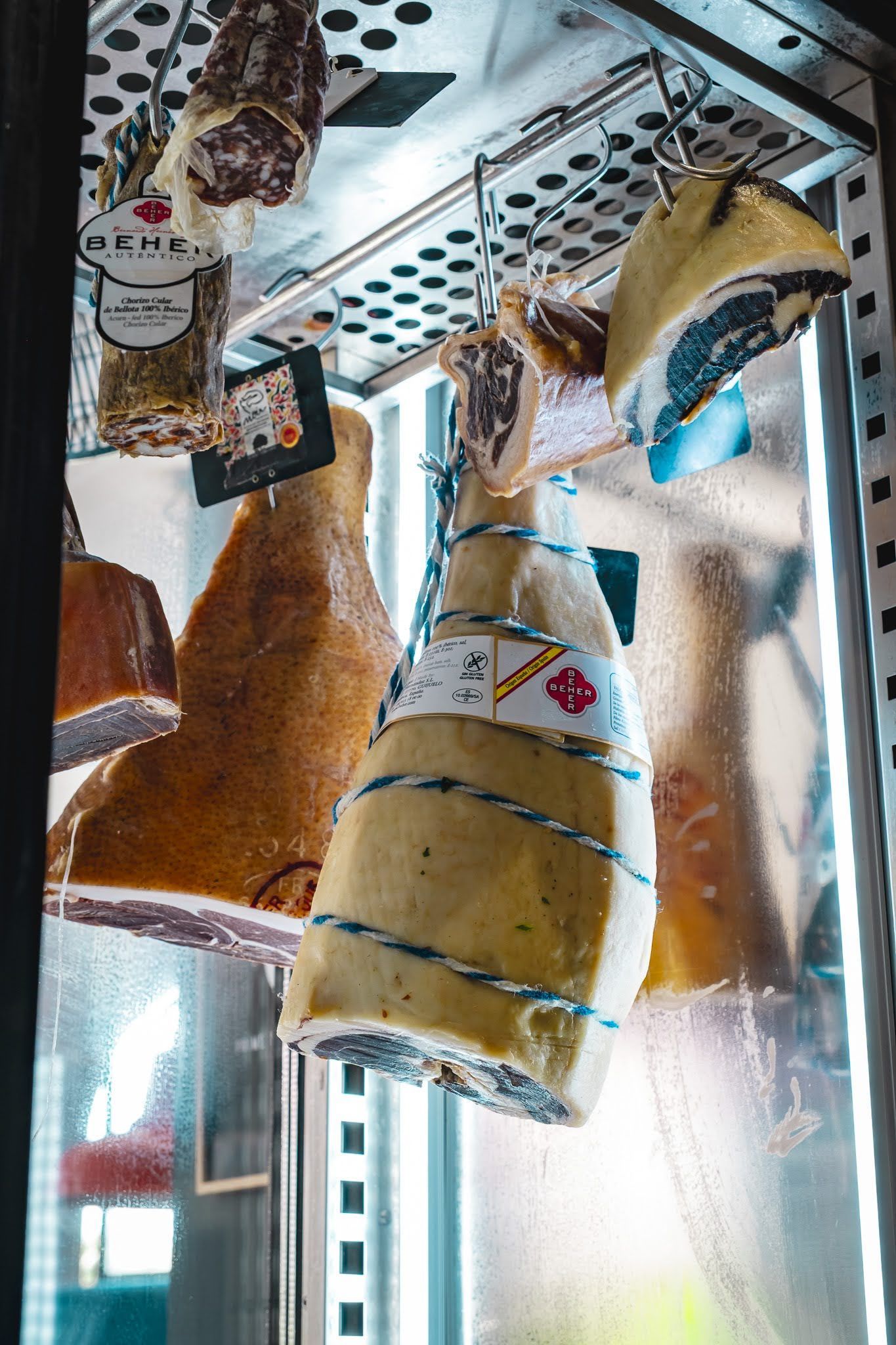 Hanging decorative fabric fish and shells displayed in a glass cabinet with shelves