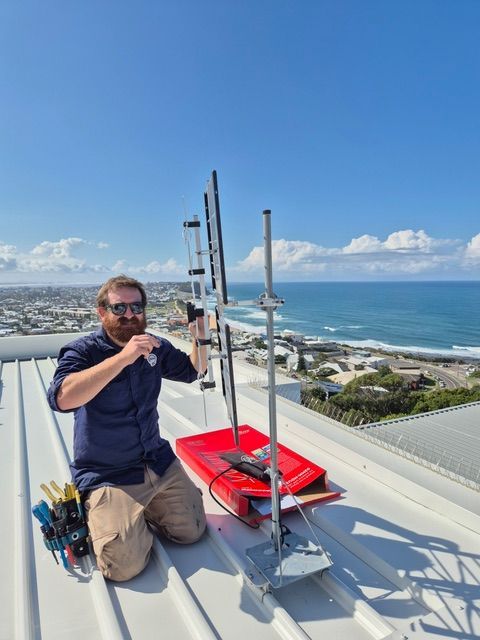 Cell Tower on Building Against a Clear Blue Sky — Powered By JBES In Sandgate, NSW