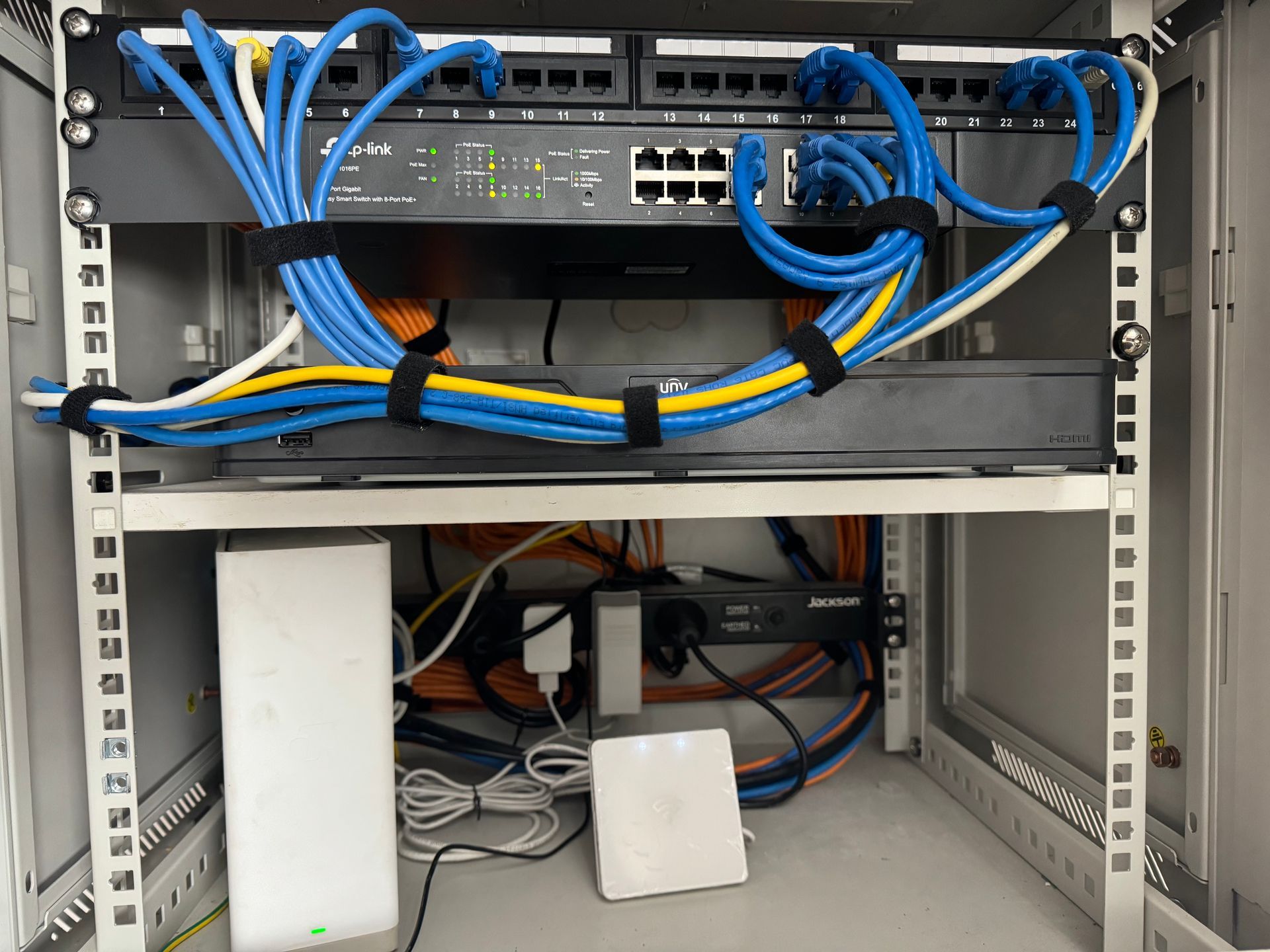 Network server rack with switches, cables, and other hardware. Blue, yellow cables - Powered By JBES In Sandgate, NSW