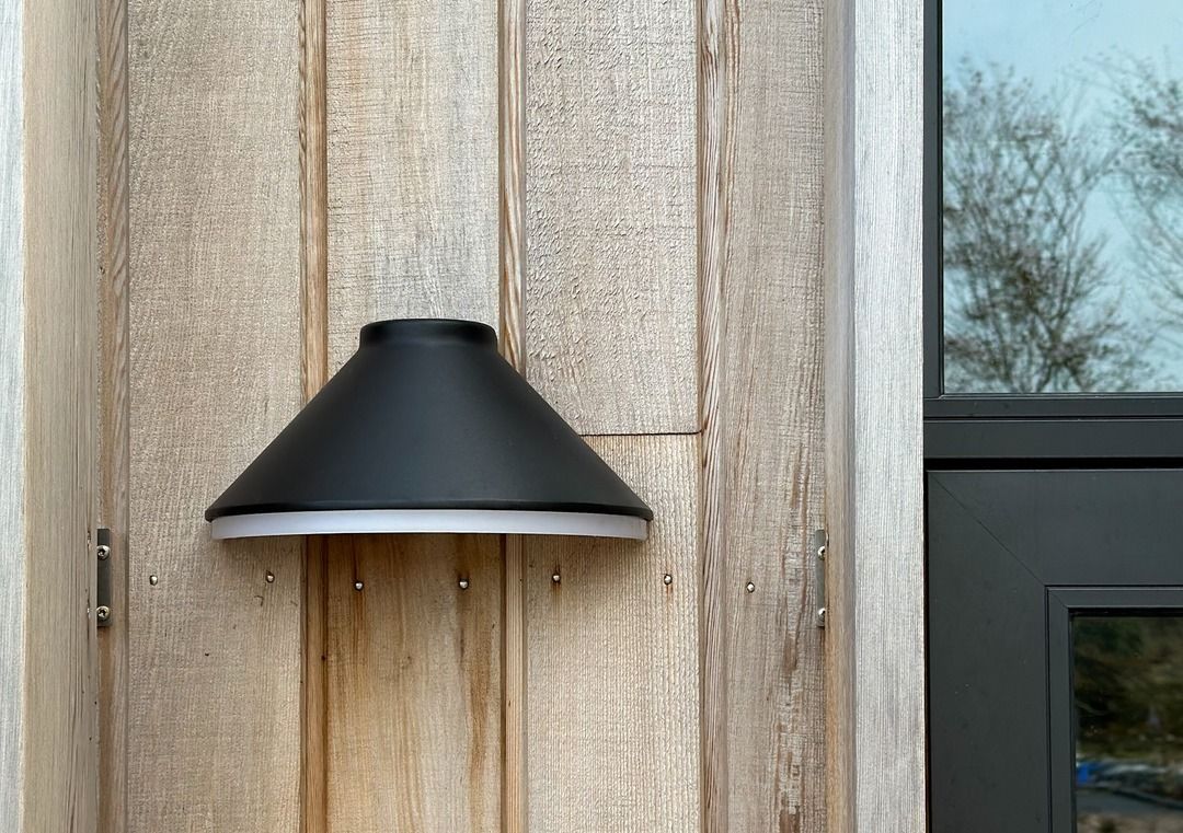 NIGHTLITE WALL Sort væglampe monteret på træfacade til moderne og dekorativ udendørsbelysning.