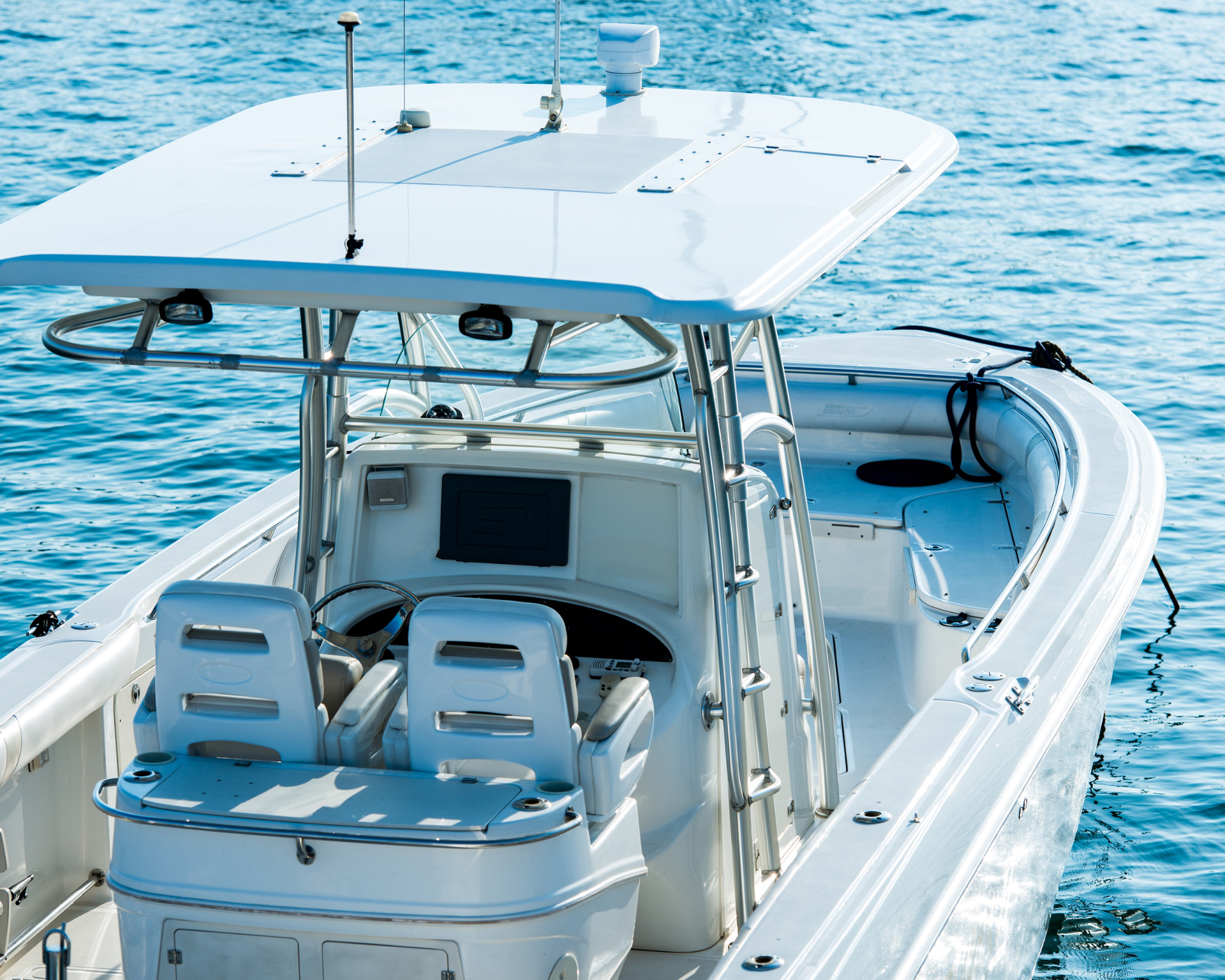 White motorboat with a canopy on blue water.