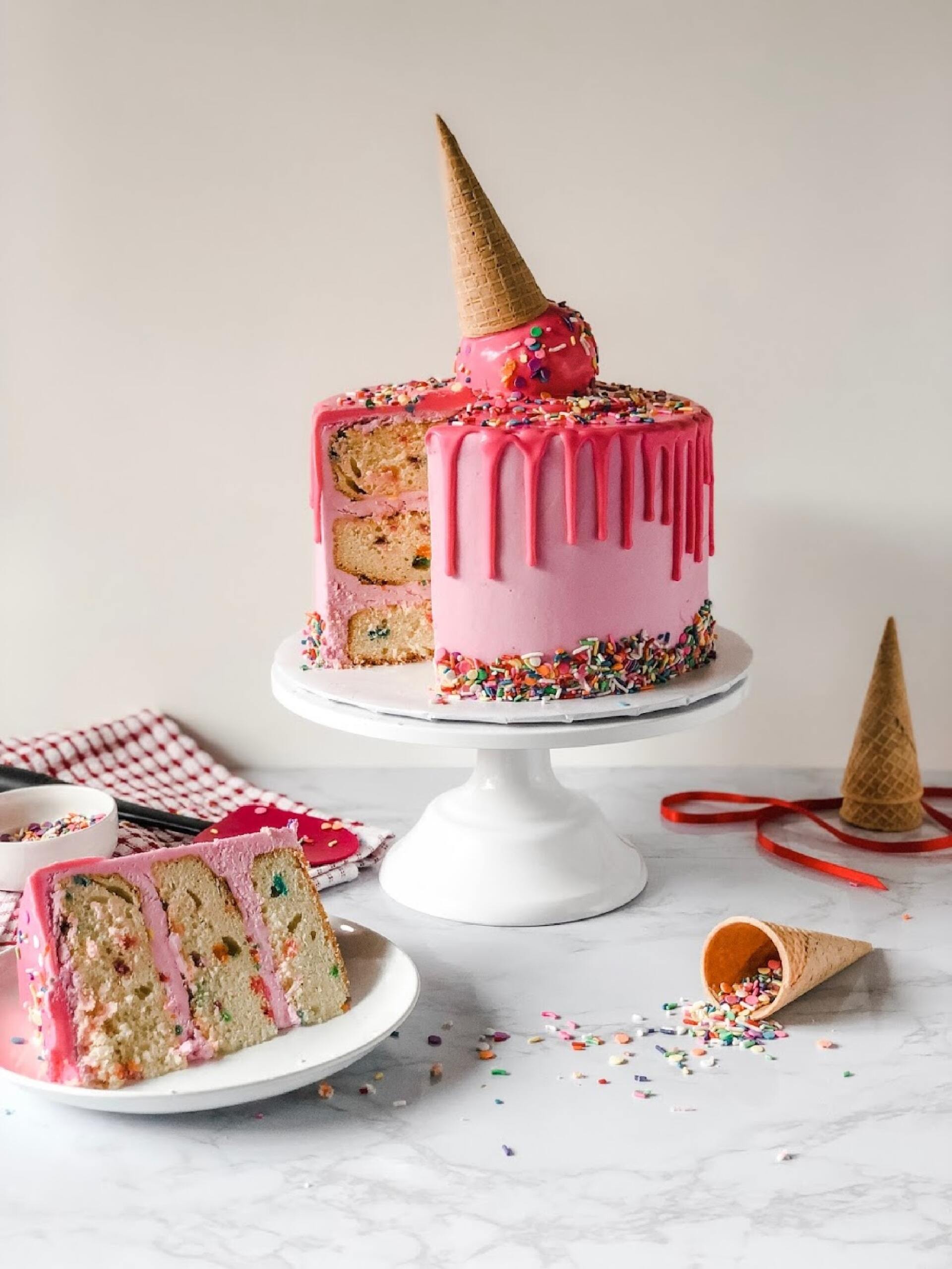 Children’s birthday cake with pink icing and melting ice cream cone topper