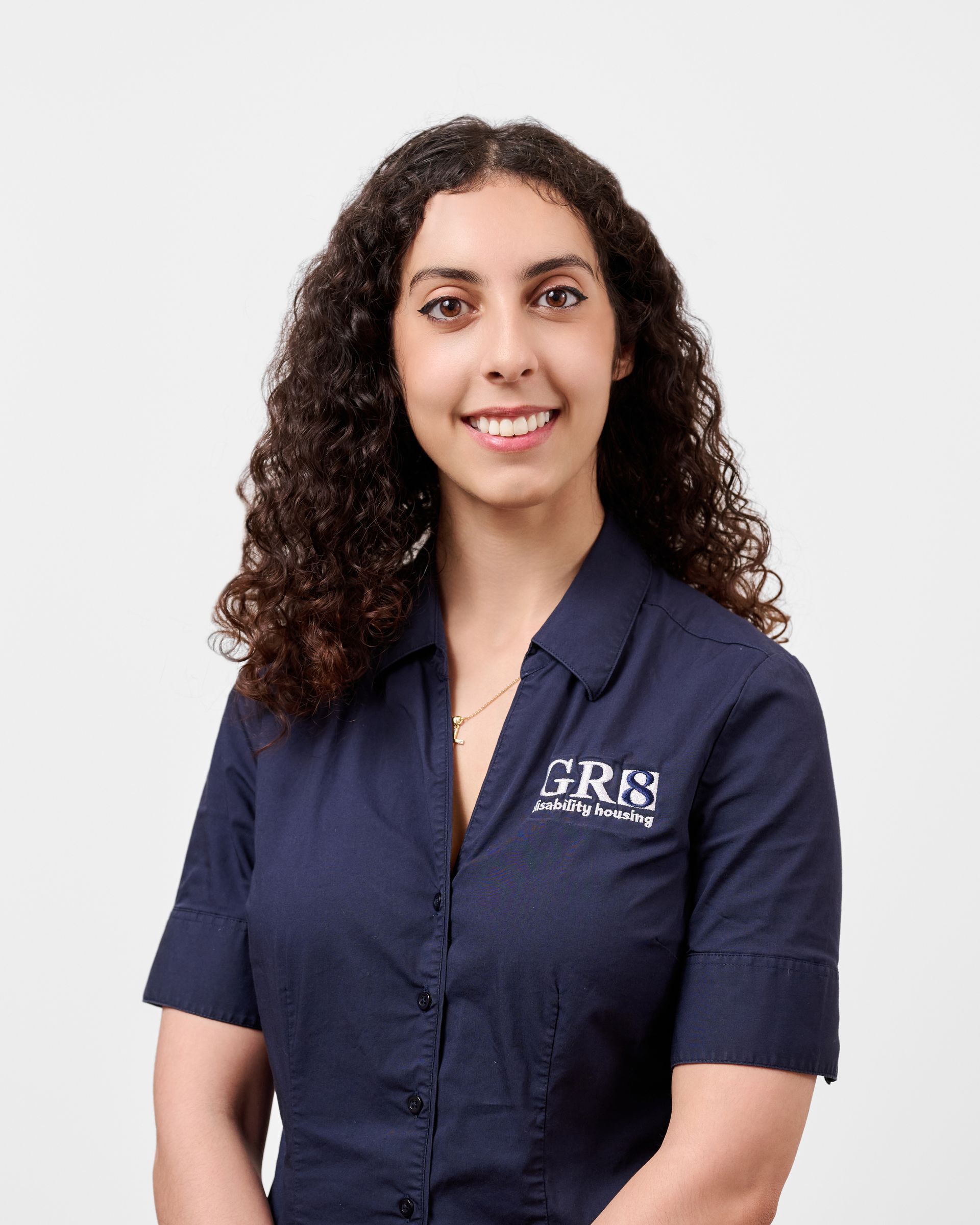 A woman in a blue shirt is smiling for the camera.